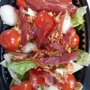 Ensalada de brotes, perlas de melón, cherry, jamón y cebolla crujiente.